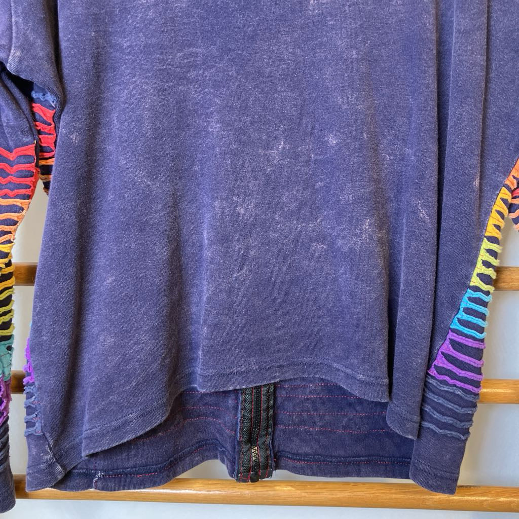 Purple t-shirt with colorful sleeves on a wooden rack