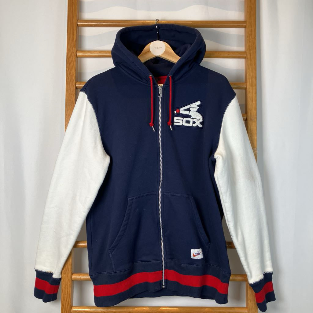 Navy and white hoodie with red accents on a wooden rack against a white background