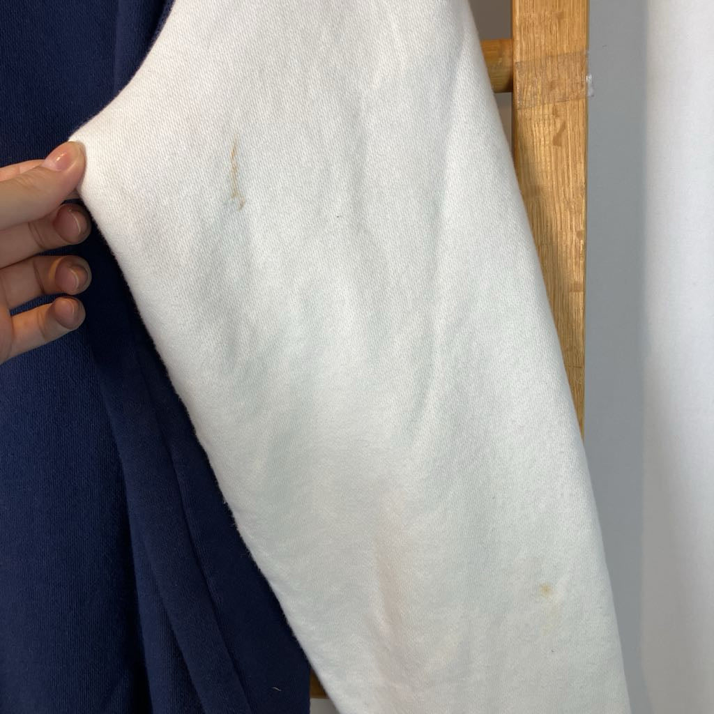 White fabric with a visible stain held by a person against a neutral background