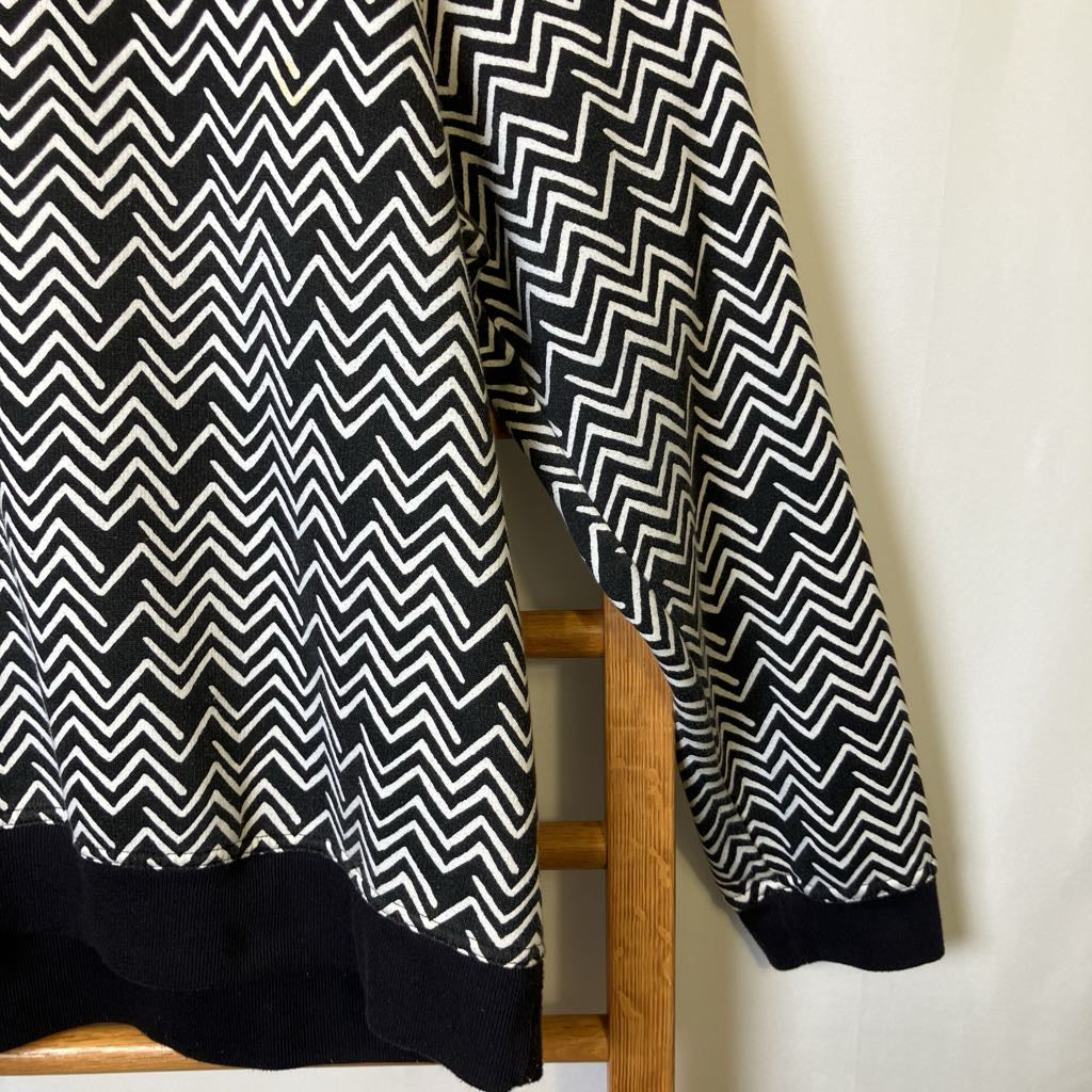 Black and white zigzag patterned curtain draped over a wooden chair.