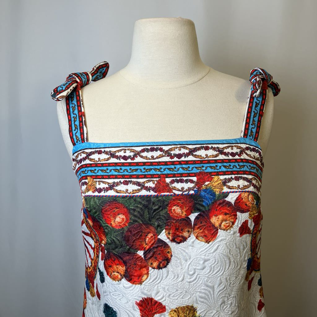 Colorful floral dress on a mannequin against a plain background