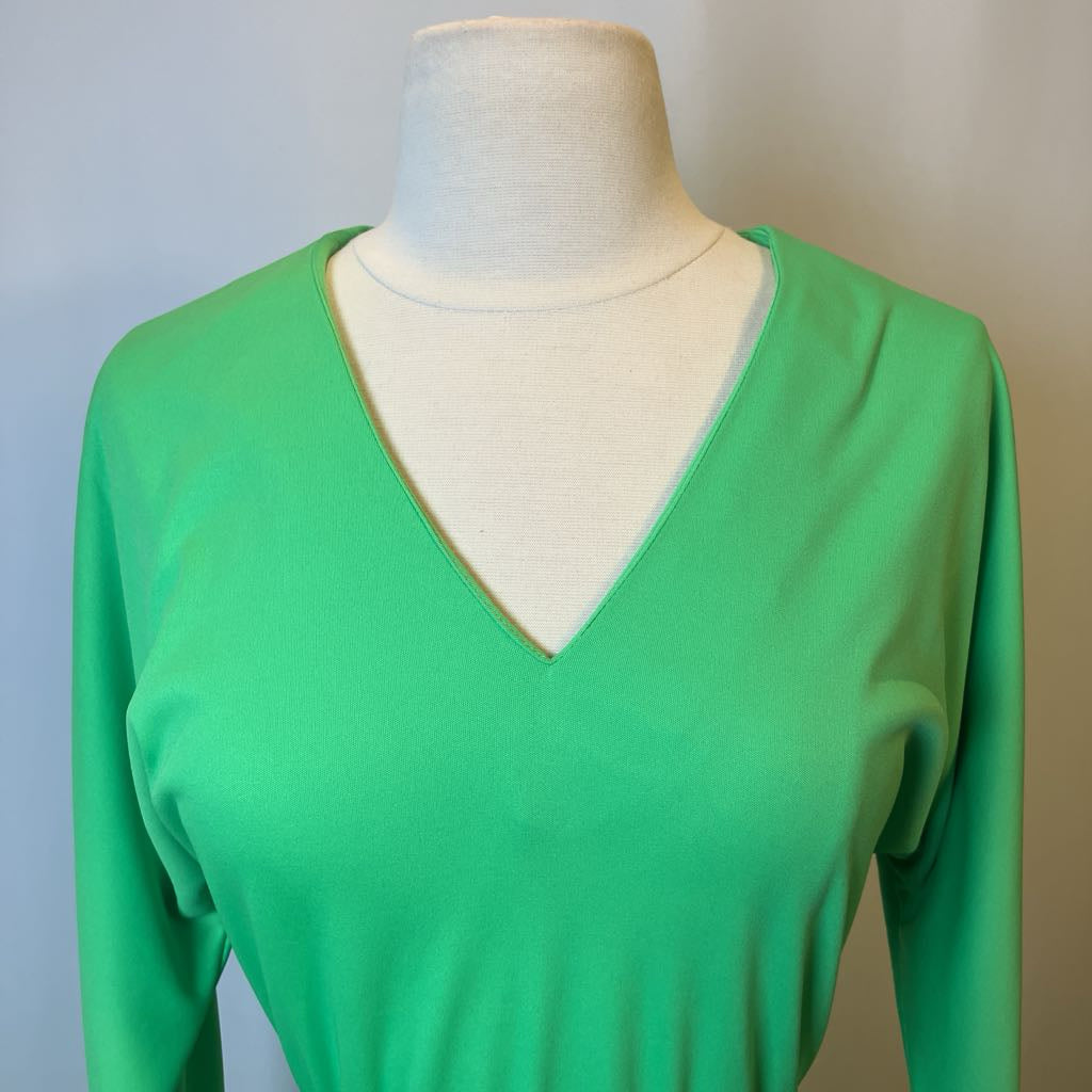 Green long-sleeve top on a mannequin against a plain background