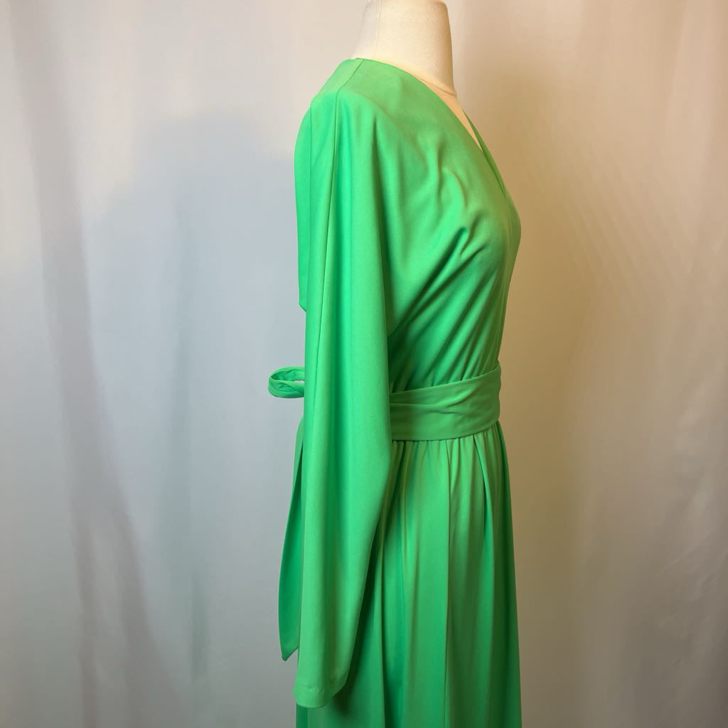 Green dress on a mannequin against a plain background