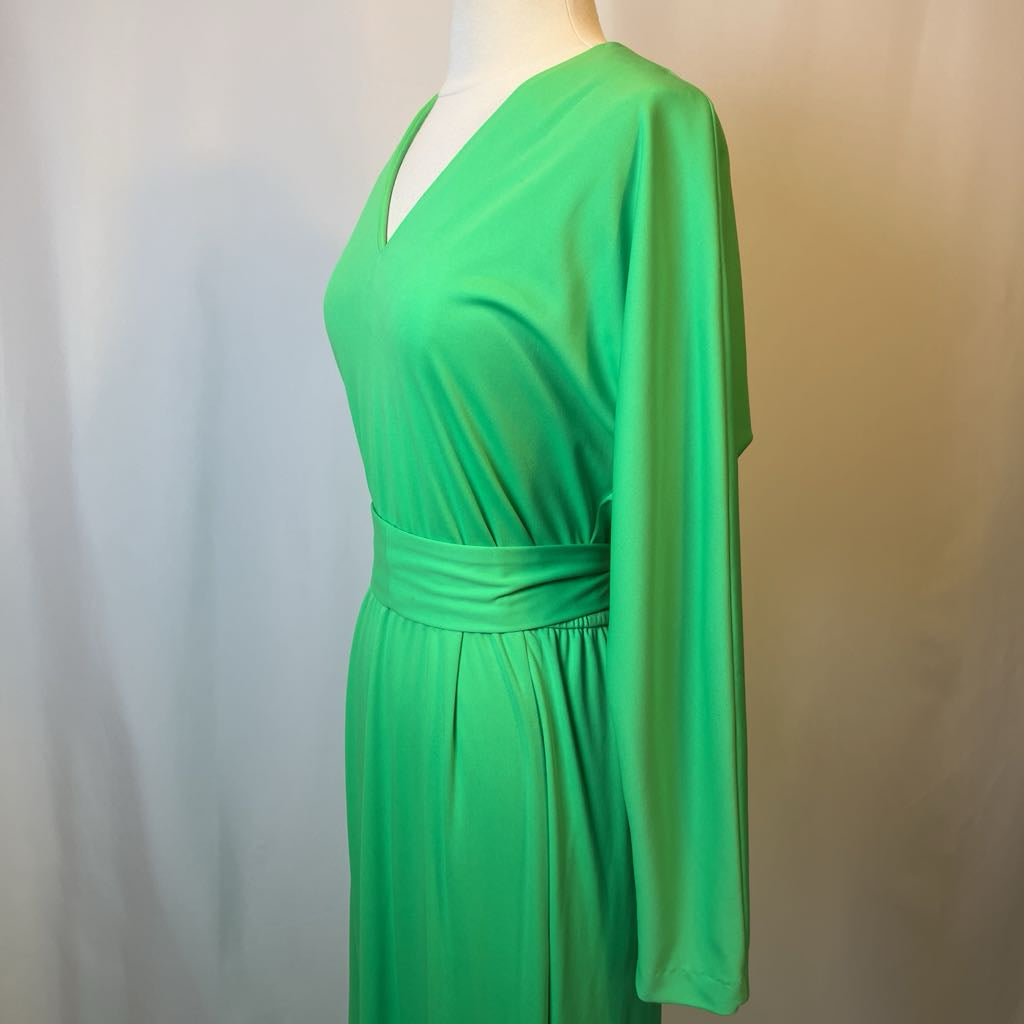 Green dress on a mannequin against a neutral background