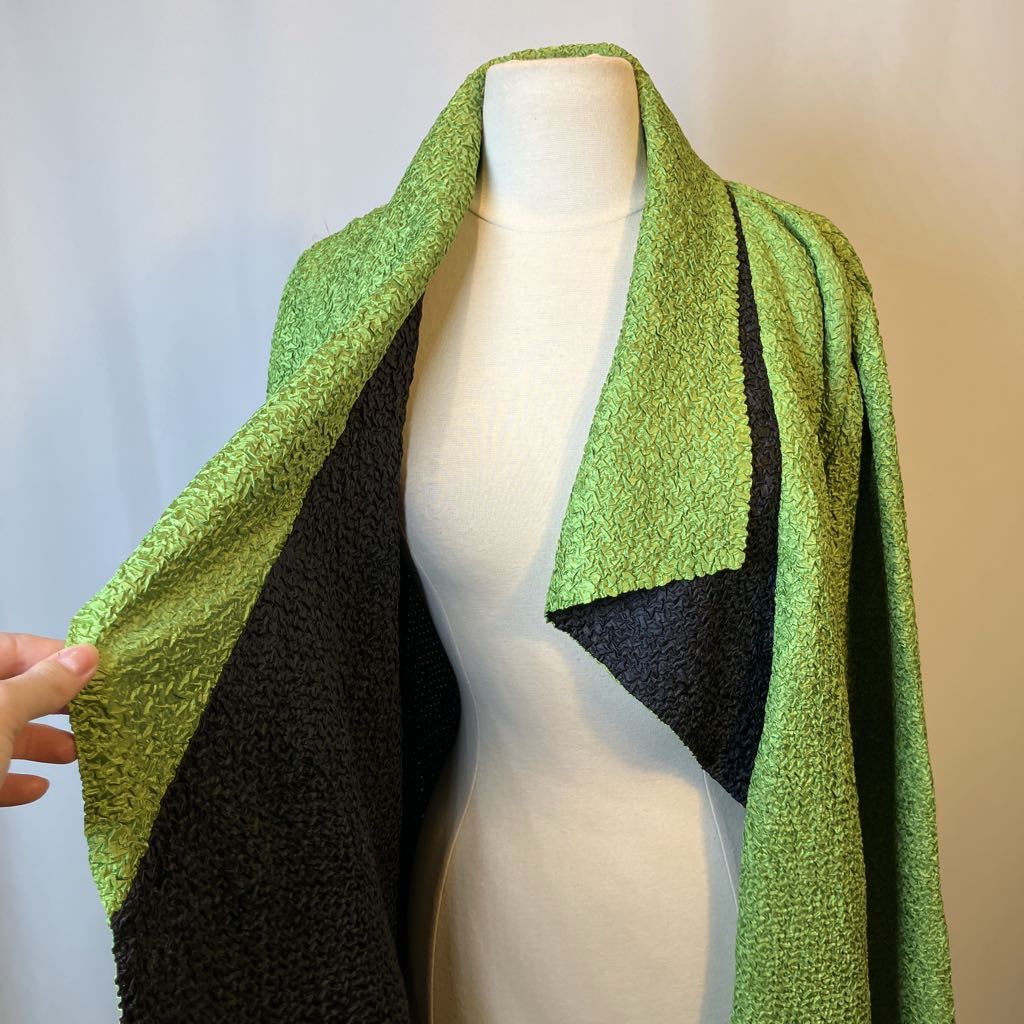 Mannequin wearing a green and black patterned jacket against a plain background