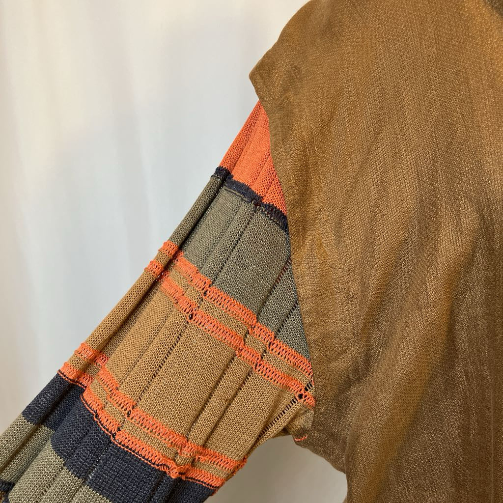 Close-up of a brown sweater with orange and green pattern on a white background