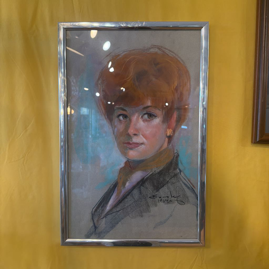 Framed portrait of a woman with red hair on a yellow wall