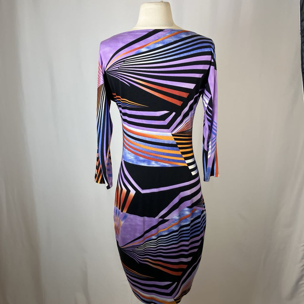 Colorful geometric-patterned dress on a mannequin against a plain background