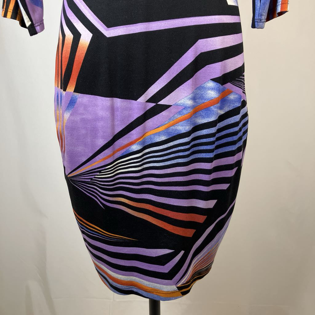 Mannequin wearing a dress with geometric multicolor pattern on a plain background