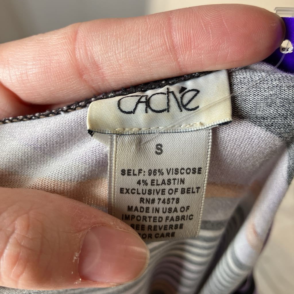 Close-up of a Cache label on fabric with a hand holding it.