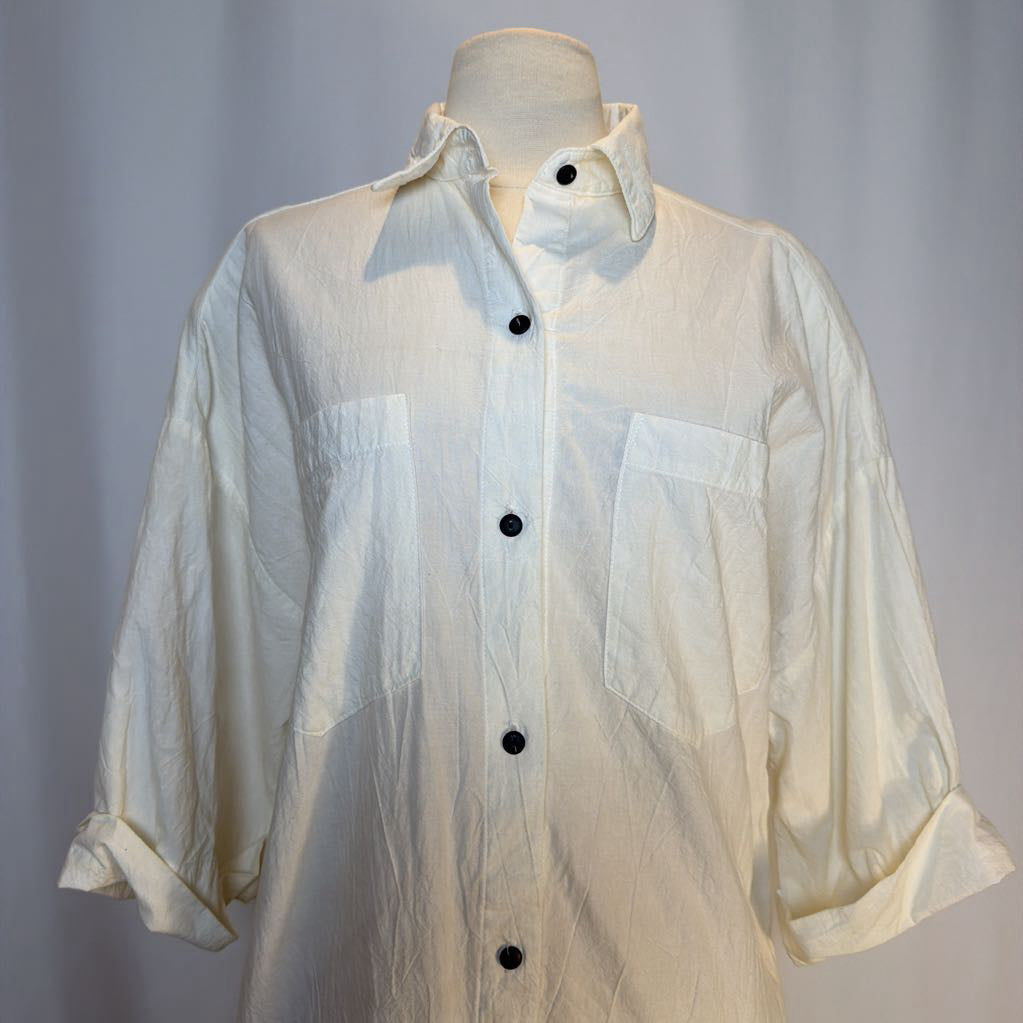 White sheer shirt with black buttons on a mannequin against a gray background