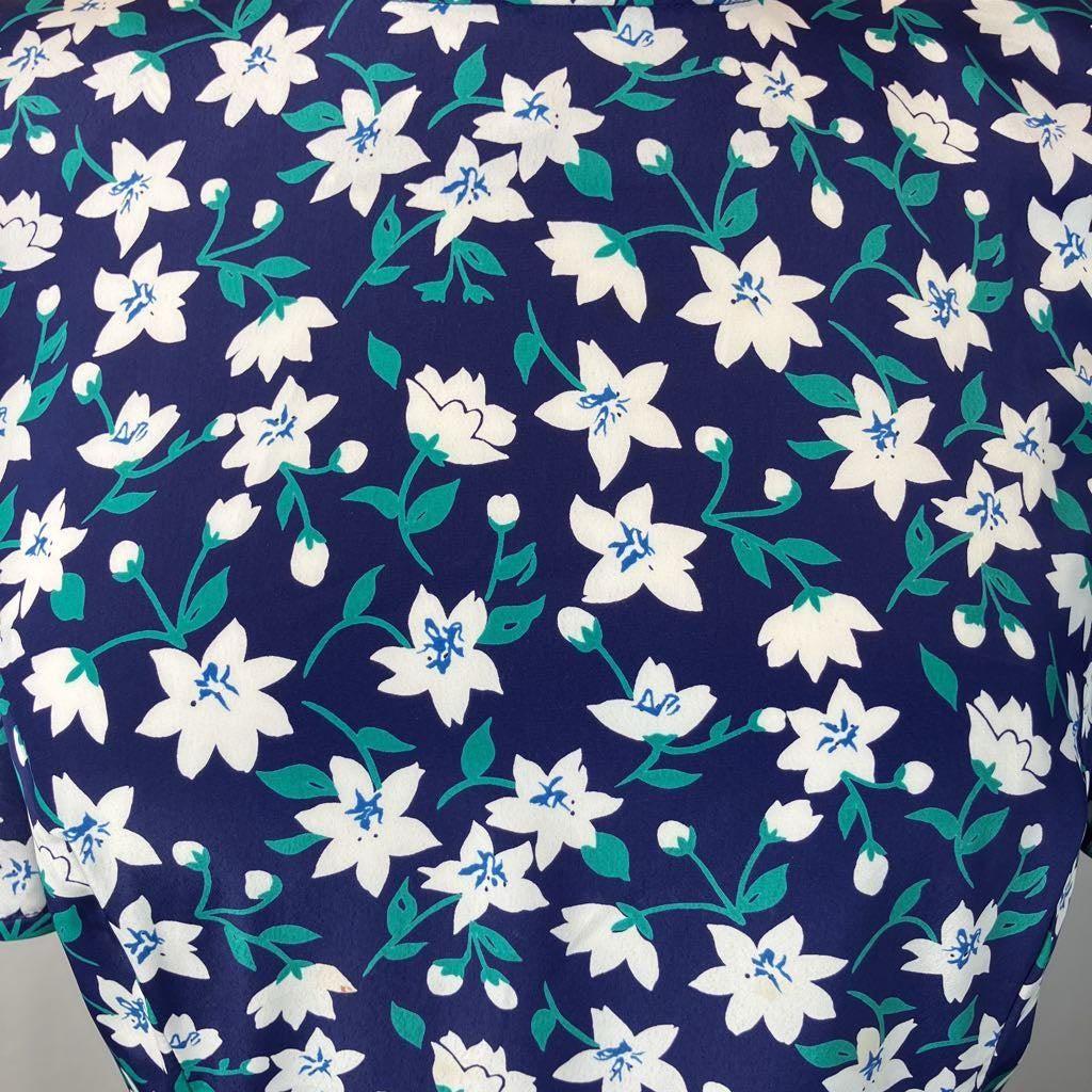 Navy blue dress with white floral pattern on a mannequin against a plain background