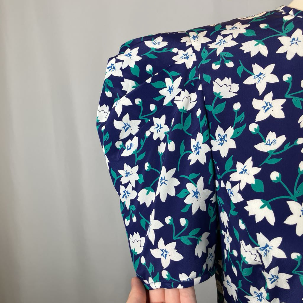 Navy blue dress with white floral pattern on a mannequin against a plain background