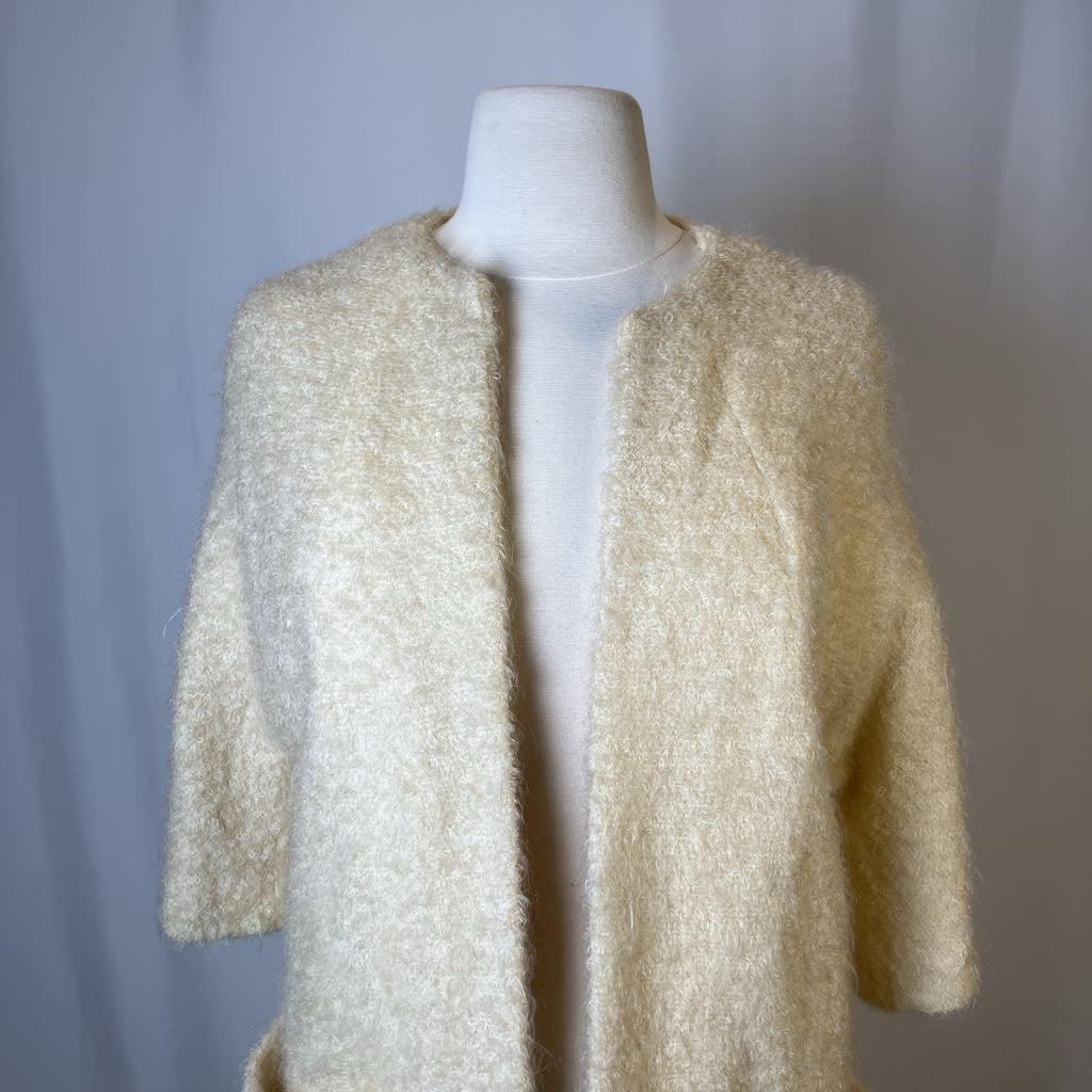 Beige textured cardigan on a mannequin against a plain background