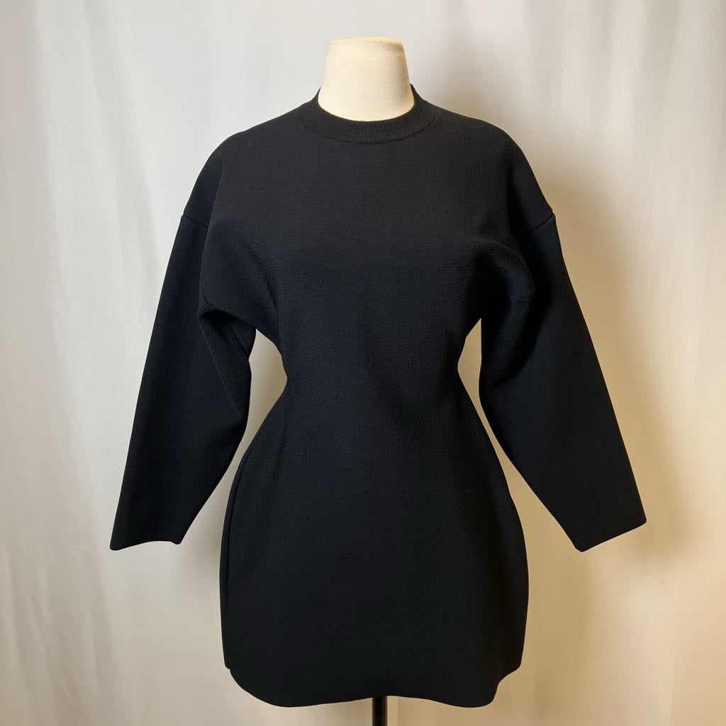 Black dress on a mannequin against a plain background