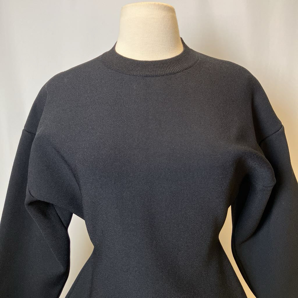 Dark gray sweater on a mannequin against a plain background