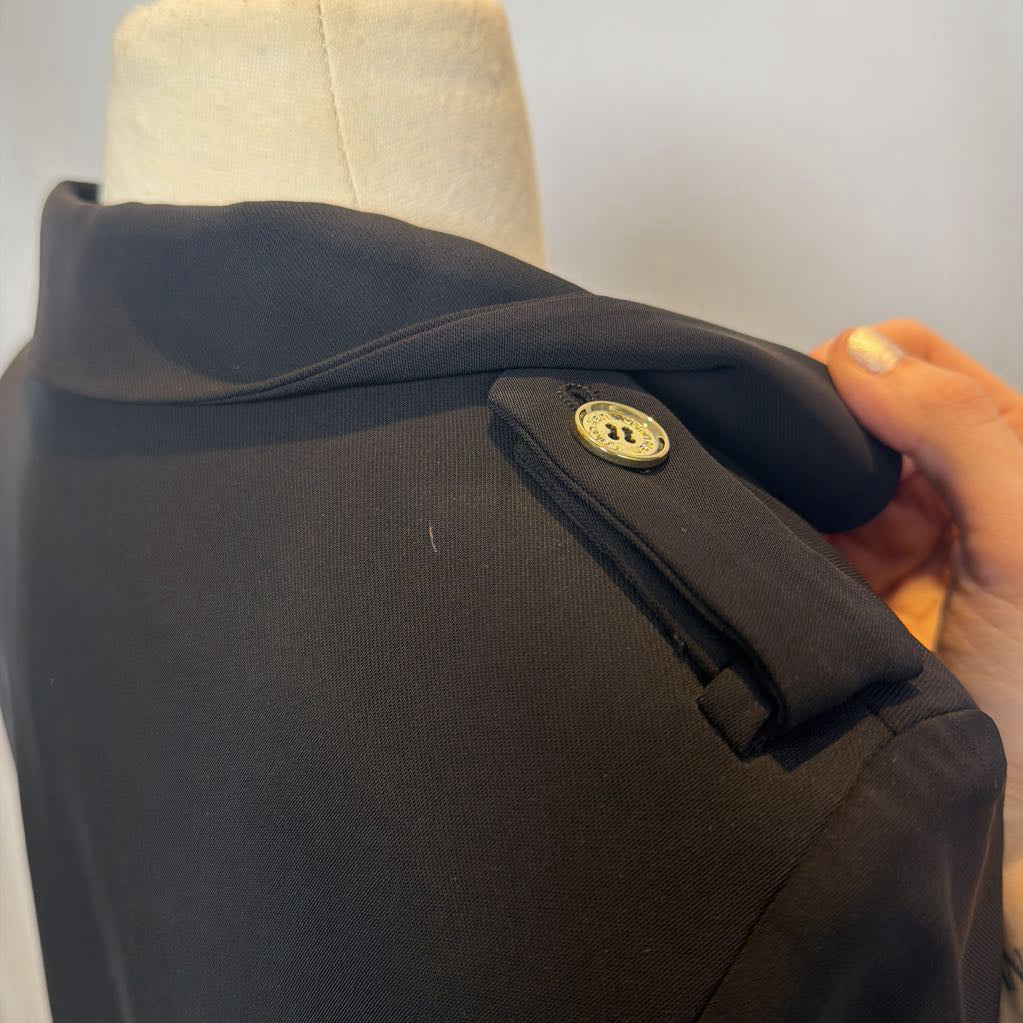 Black coat dress with a brand logo on a mannequin against a neutral background