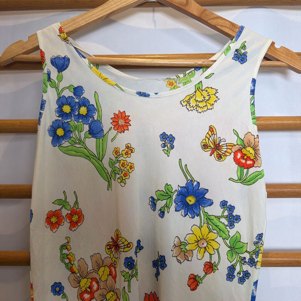 Floral-patterned sleeveless top on a hanger against a white background