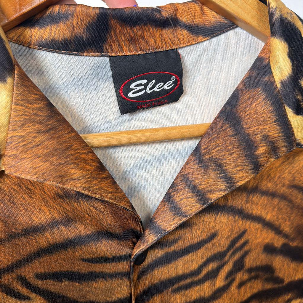 Close-up of a tiger-striped fabric with an 'Elee' label on a wooden background