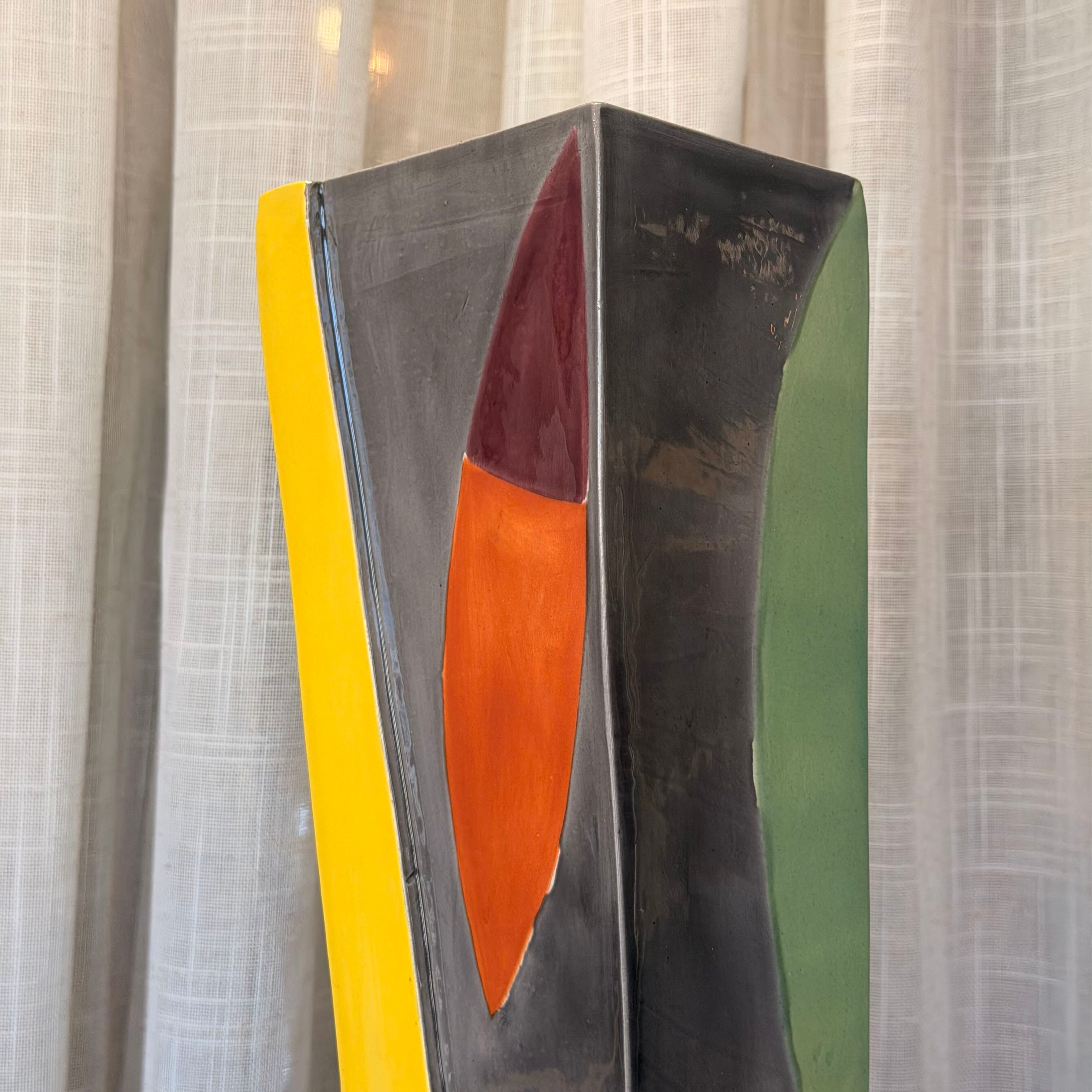 Abstract art piece with geometric shapes in yellow, orange, and green on a textured white background