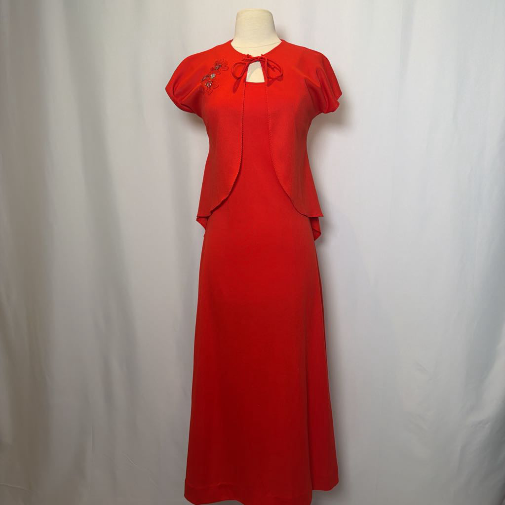 Red dress on a mannequin against a plain background