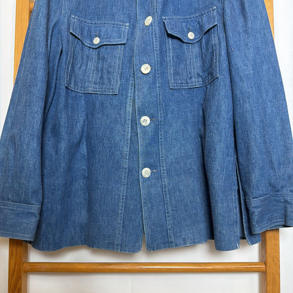 Blue denim shirt on a wooden hanger against a white background