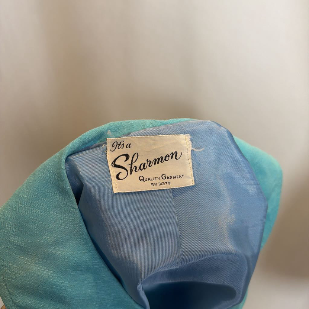 Blue garment with a 'Sharmon' label on a neutral background