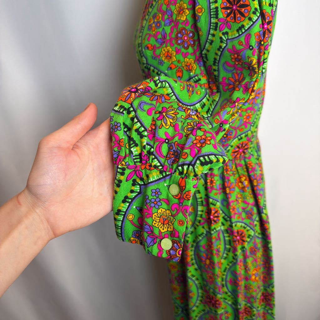 Colorful patterned fabric with a hand holding it against a neutral background