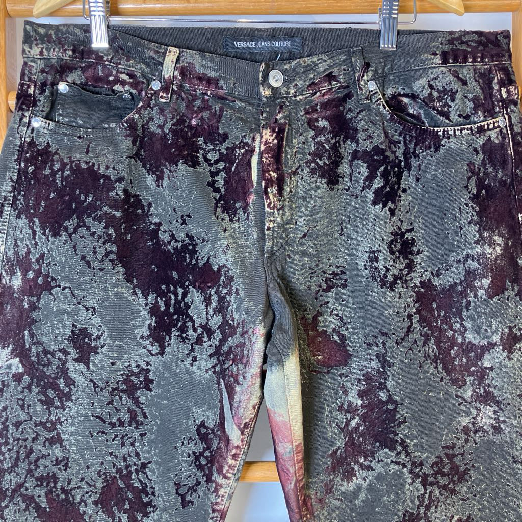 Distressed jeans with a visible brand label on a wooden hanger.