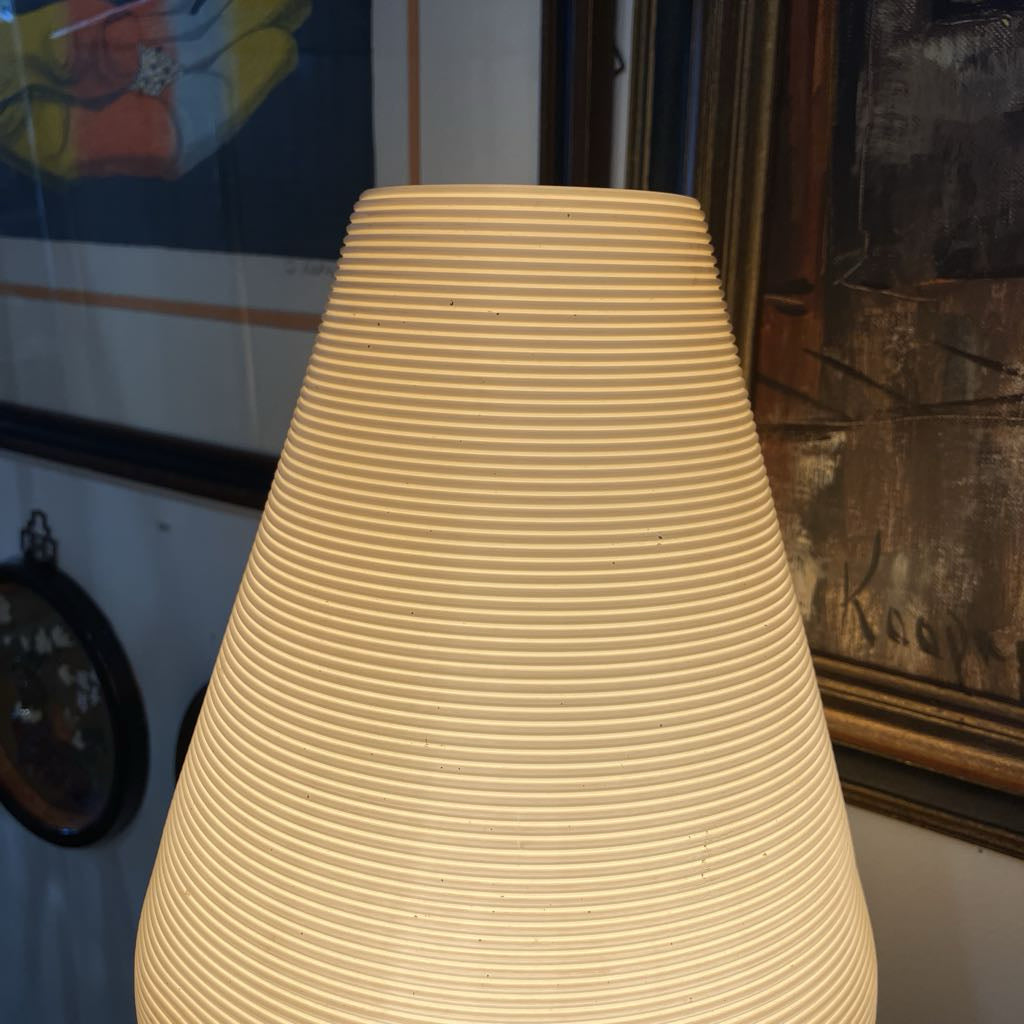 Beige textured lampshade in a room with decorative elements.