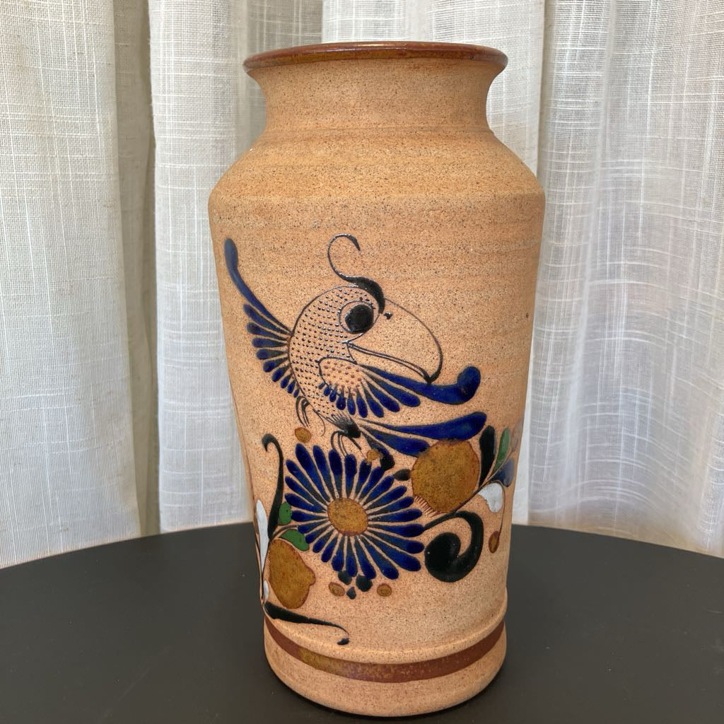 Decorative vase with bird and flower design on a plain background