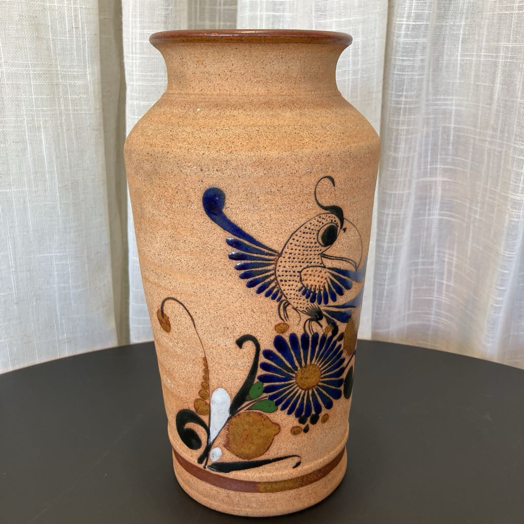 Ceramic vase with decorative bird and flower design on a plain background