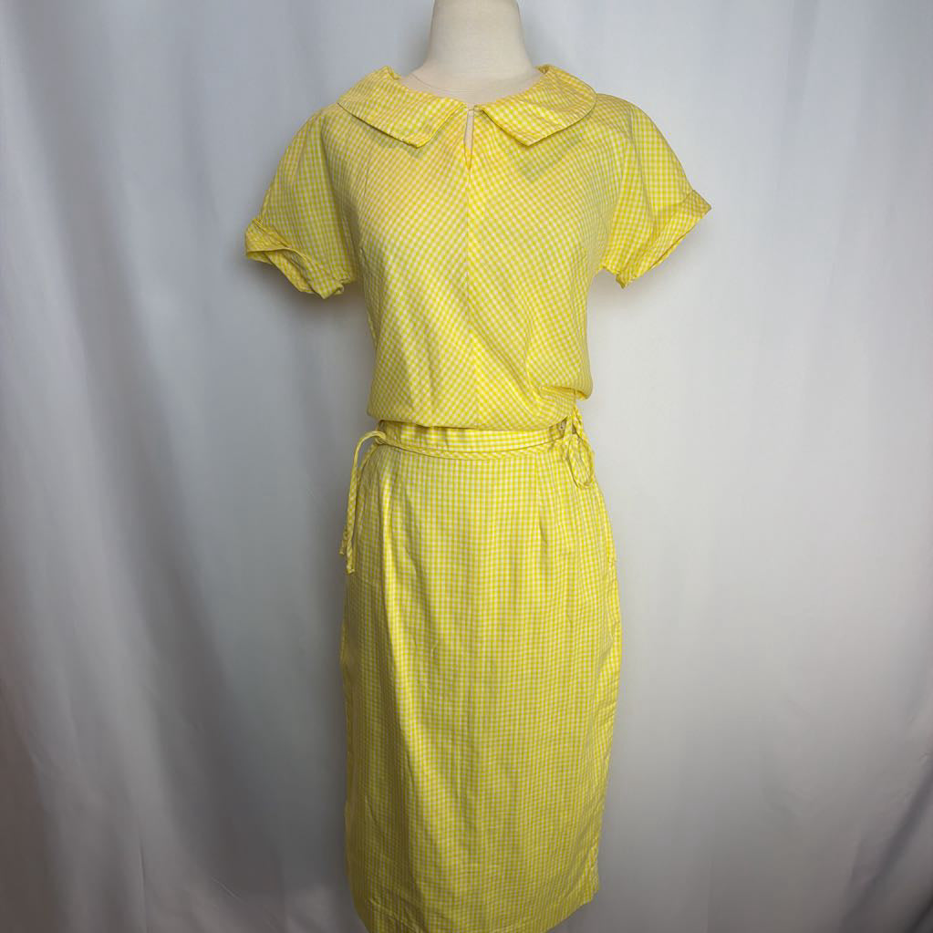 Yellow checkered dress on a mannequin against a plain background