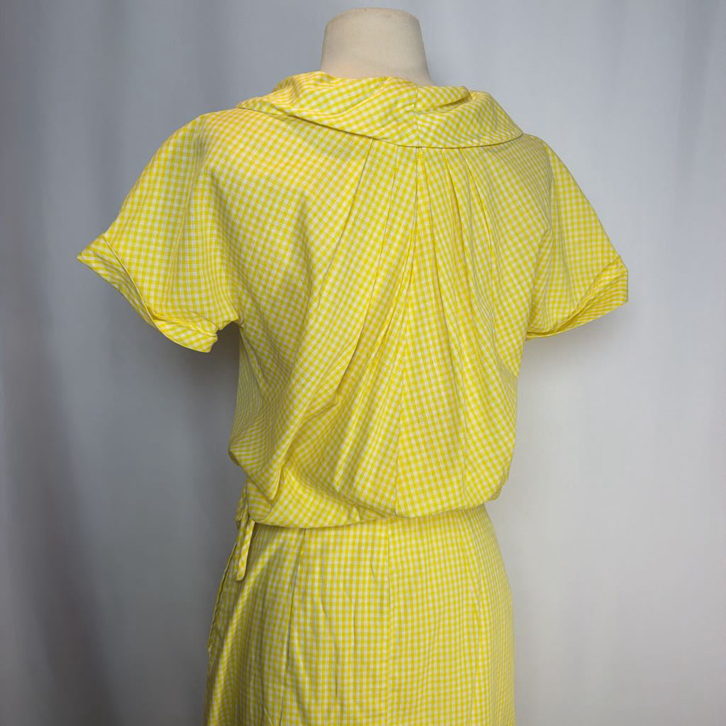 Yellow checkered dress on a mannequin against a gray background