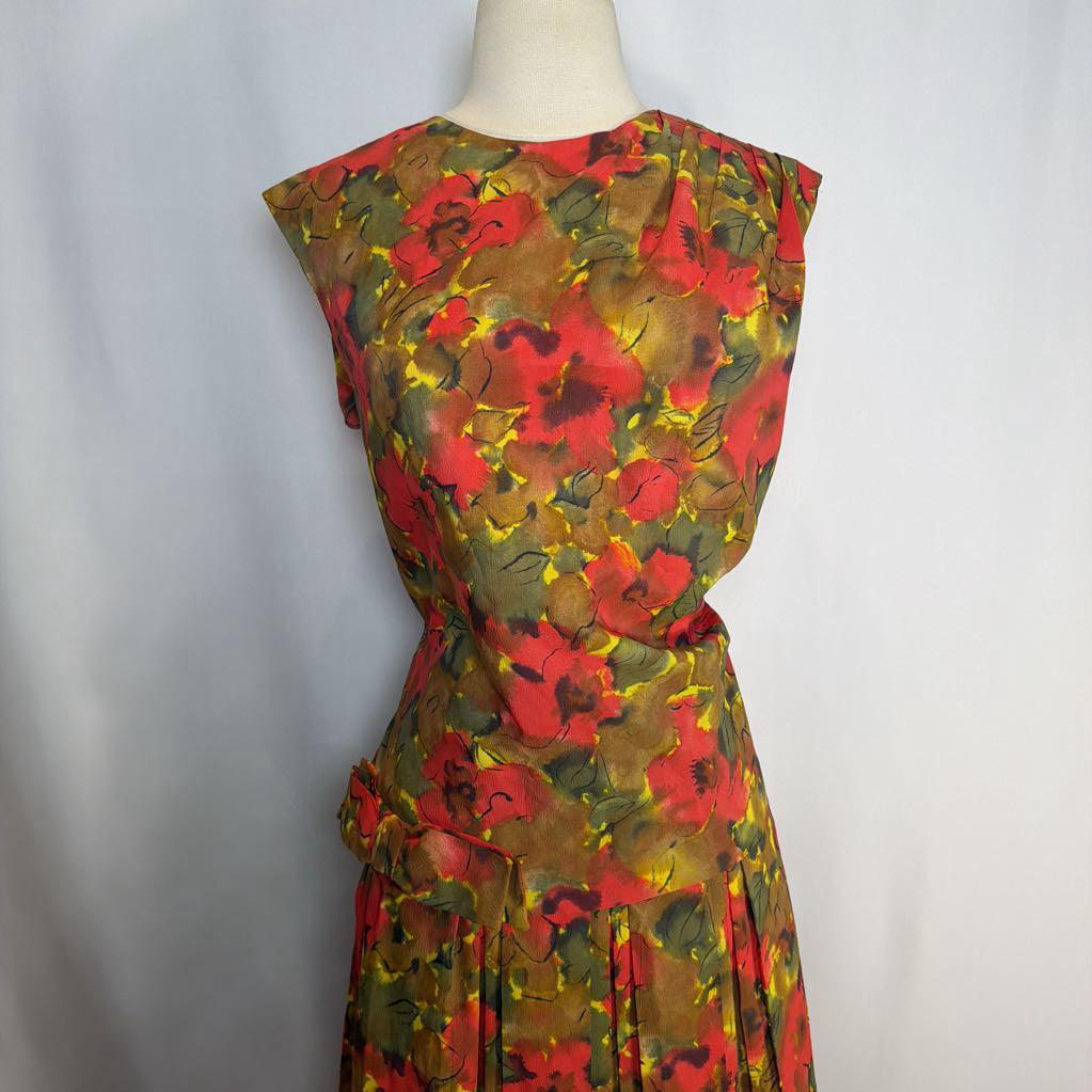 Mannequin wearing a colorful floral dress against a plain background
