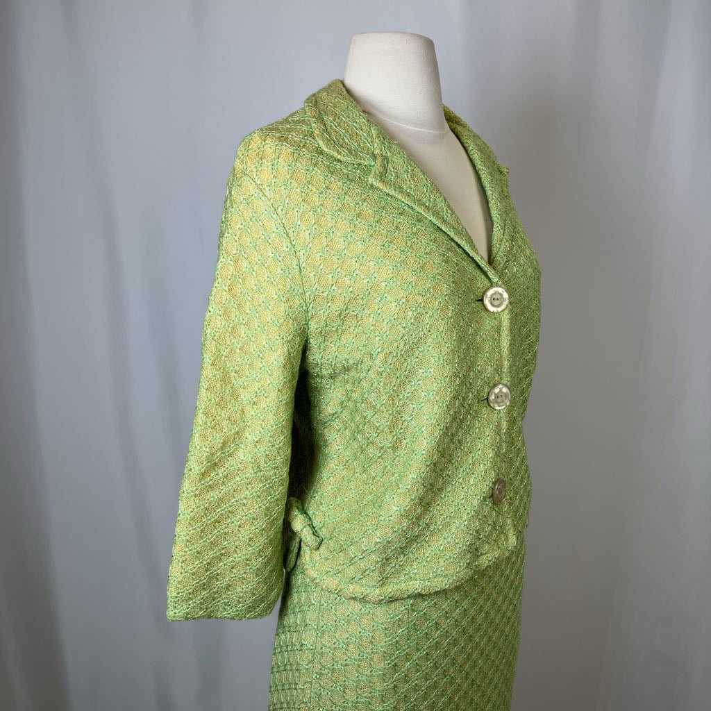 Green textured suit on a mannequin against a plain background