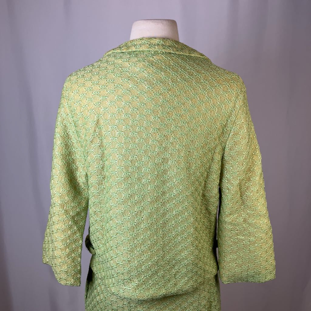 Green patterned jacket on a mannequin against a gray background