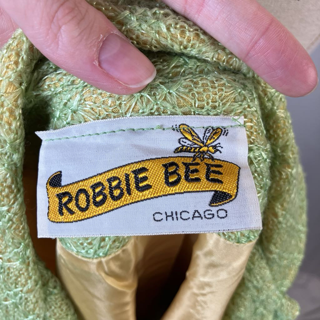Label with 'Robbie Bee Chicago' on a textured green fabric background