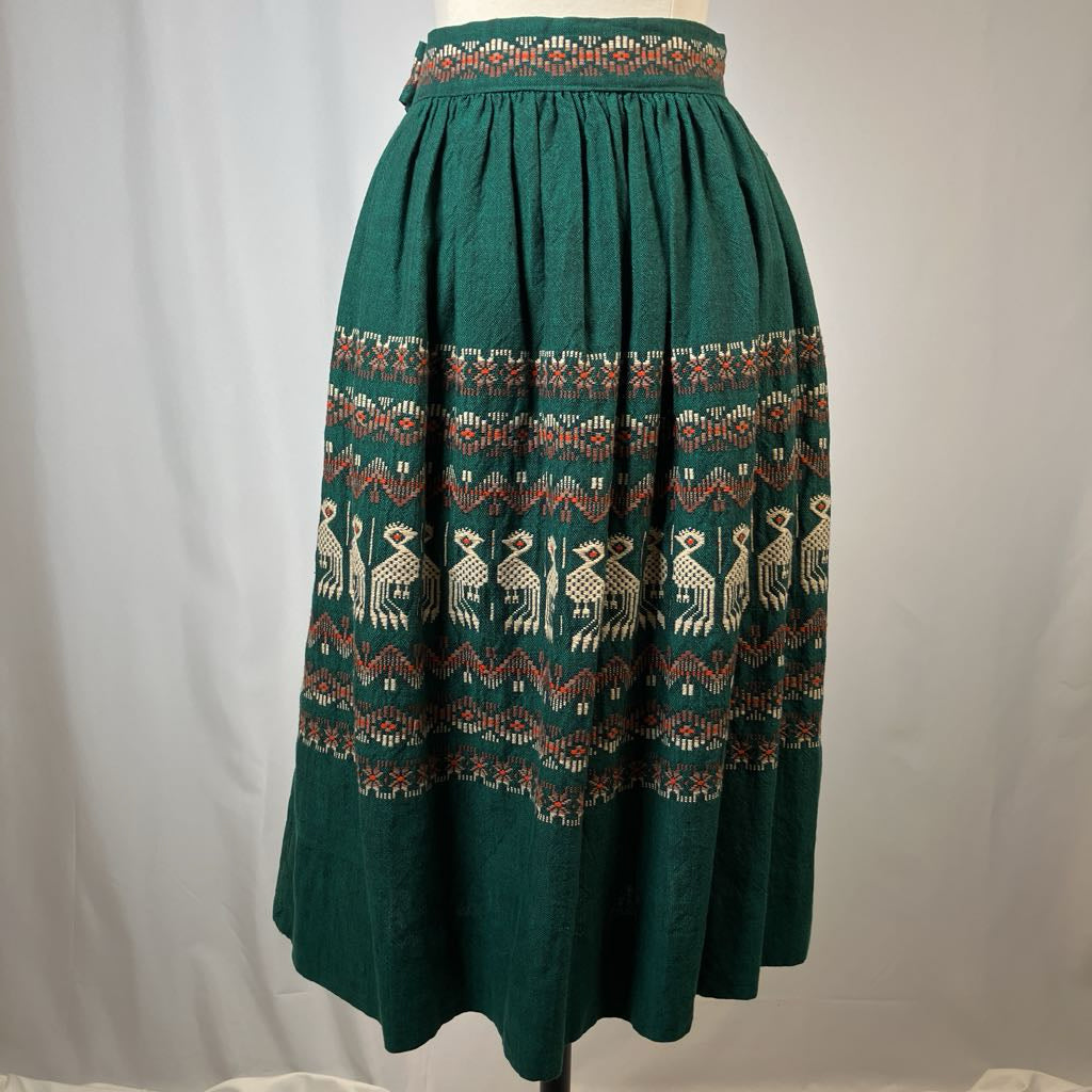 Green skirt with pattern on a mannequin against a plain background