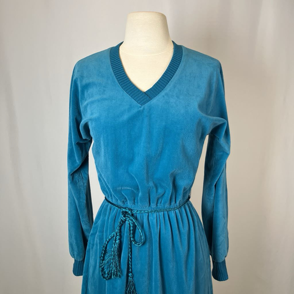 Blue dress on a mannequin against a plain background