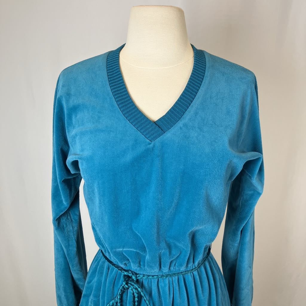 Blue dress on a mannequin against a plain background