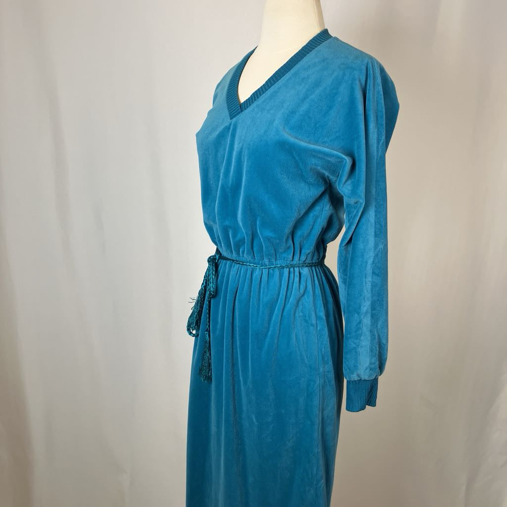 Blue dress on a mannequin against a plain background