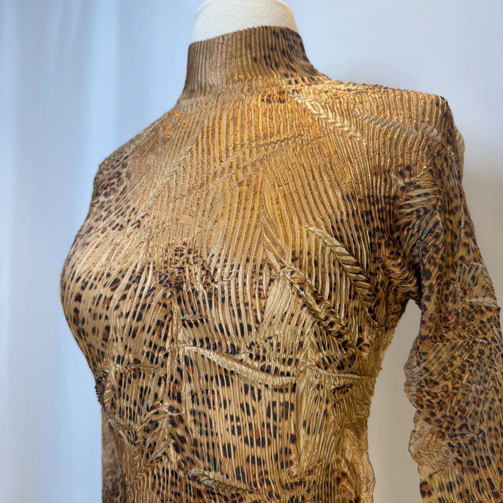 Mannequin wearing a textured brown sweater with a patterned design.