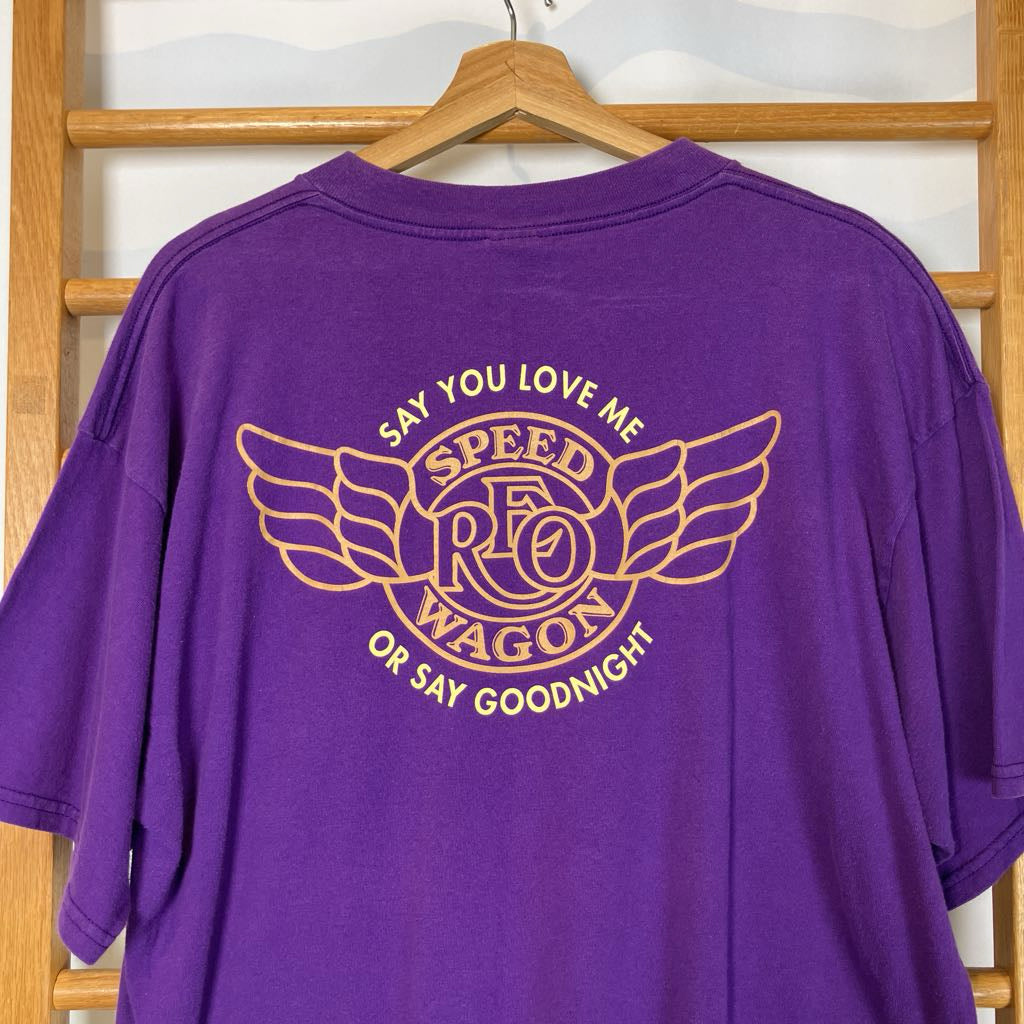 Purple t-shirt with gold graphic and text on a wooden hanger