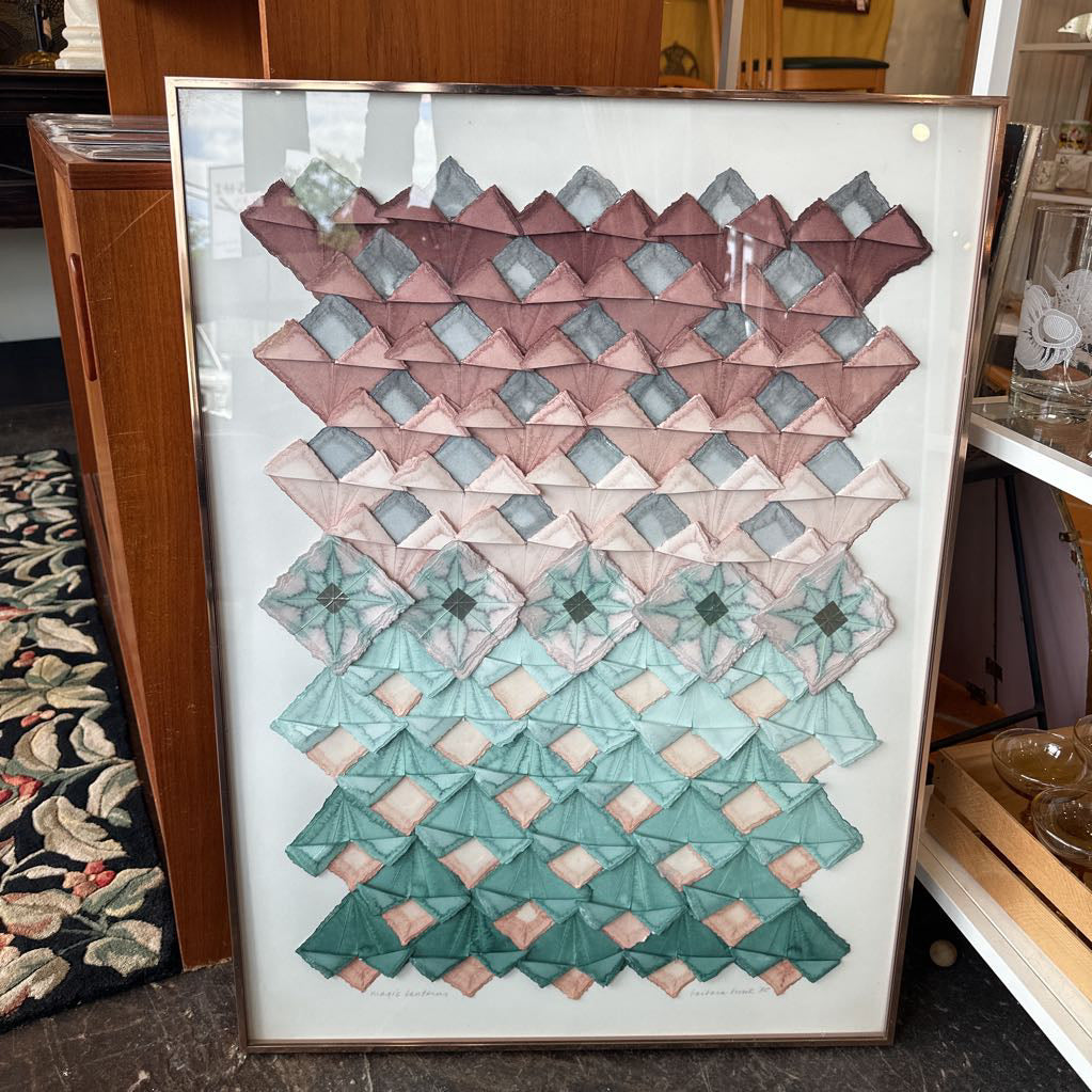 Framed geometric pattern artwork on a shelf