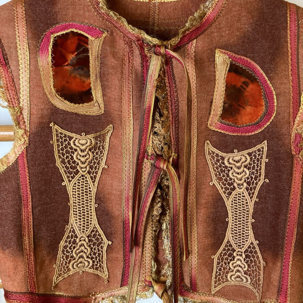 Decorative vest with intricate patterns and embroidery on a mannequin.