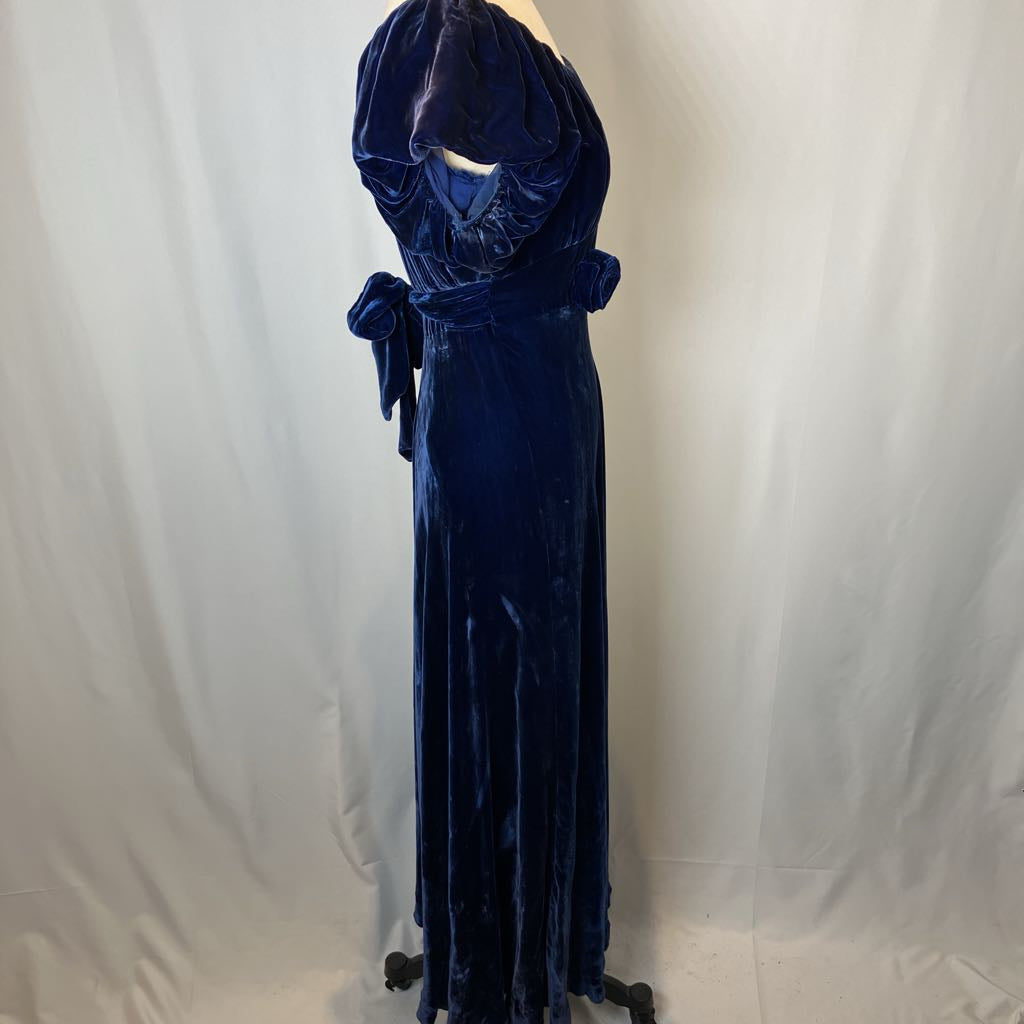 Navy blue velvet gown on a mannequin against a plain background