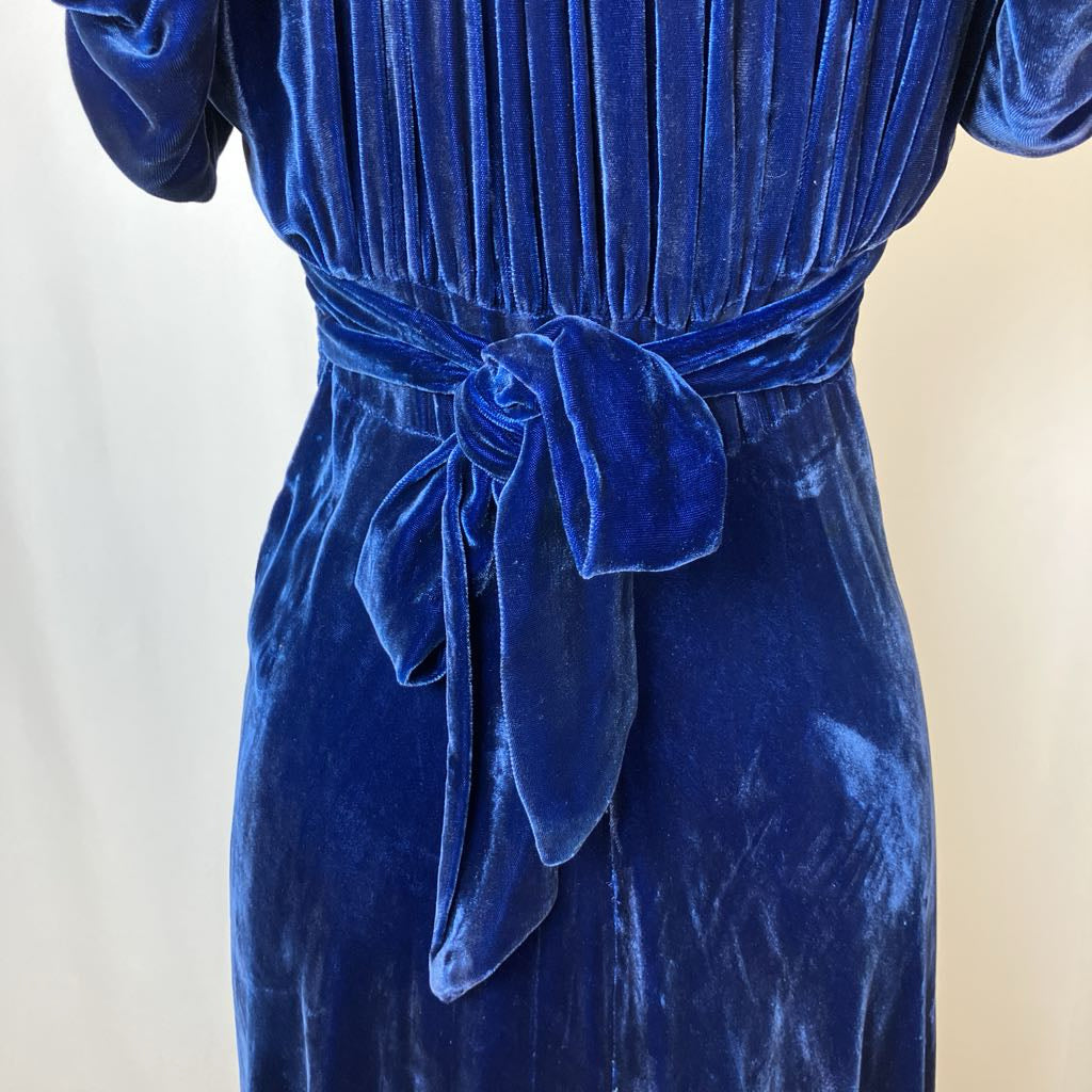 Blue velvet dress with a tie waist on a neutral background
