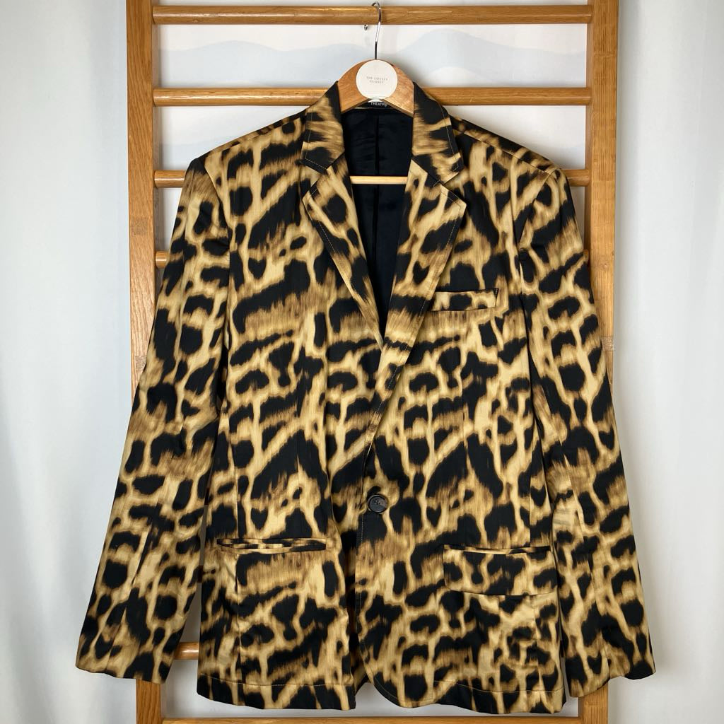 Leopard print blazer on a hanger against a white wall