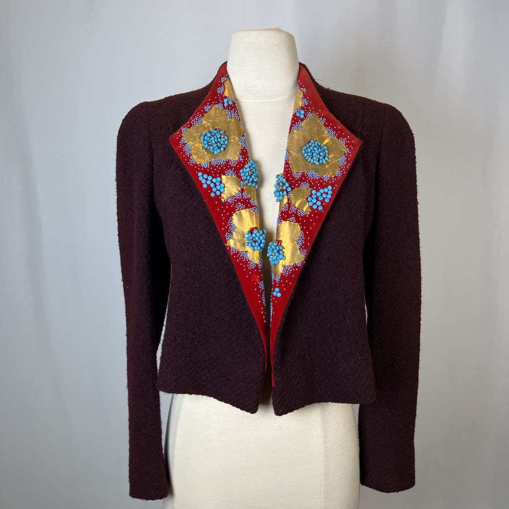 Brown blazer with colorful floral embroidery on a mannequin against a white background